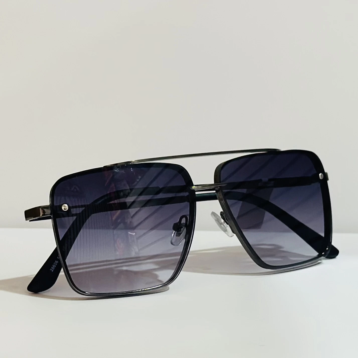 pair of square aviator sunglasses with a black metal frame and gradient lenses.