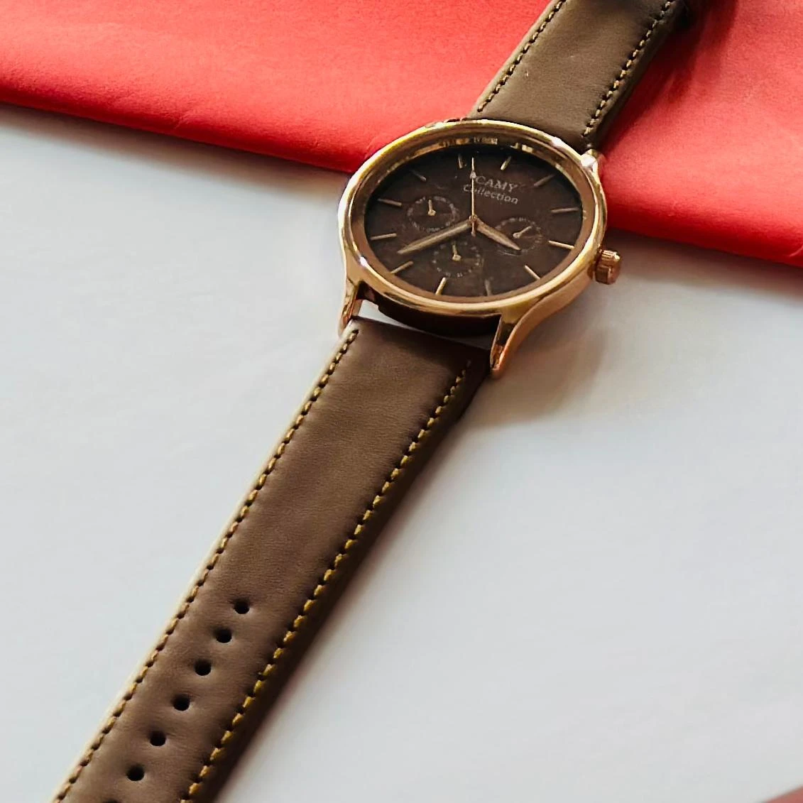 Round analog watch with a brown leather strap