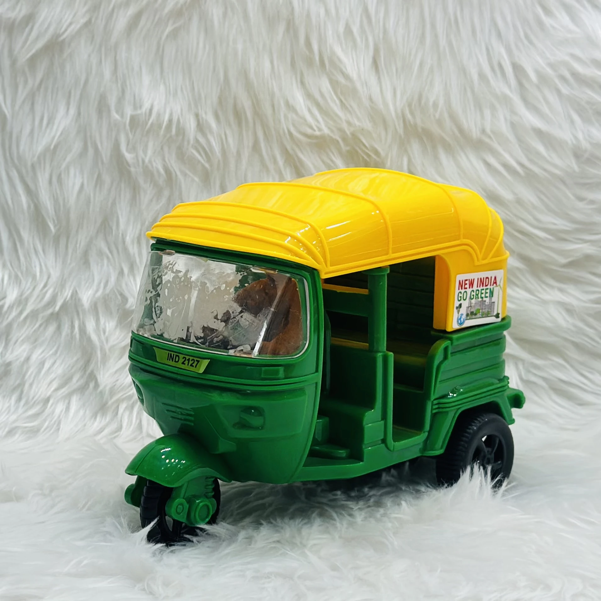 Yellow plastic toy auto rickshaw.