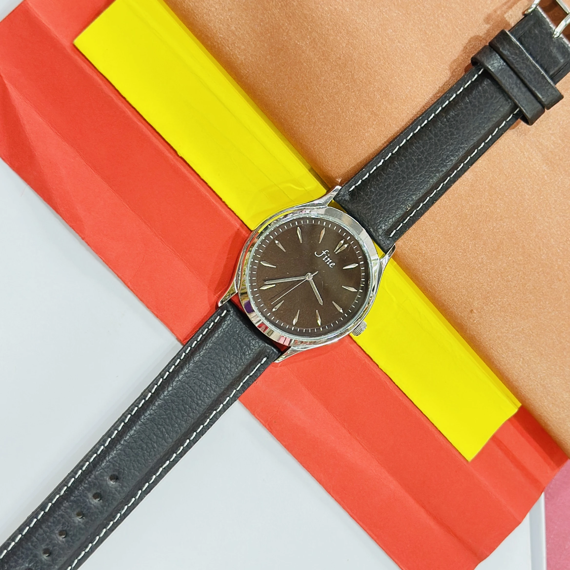 Fine" brand wristwatch featuring a black strap
