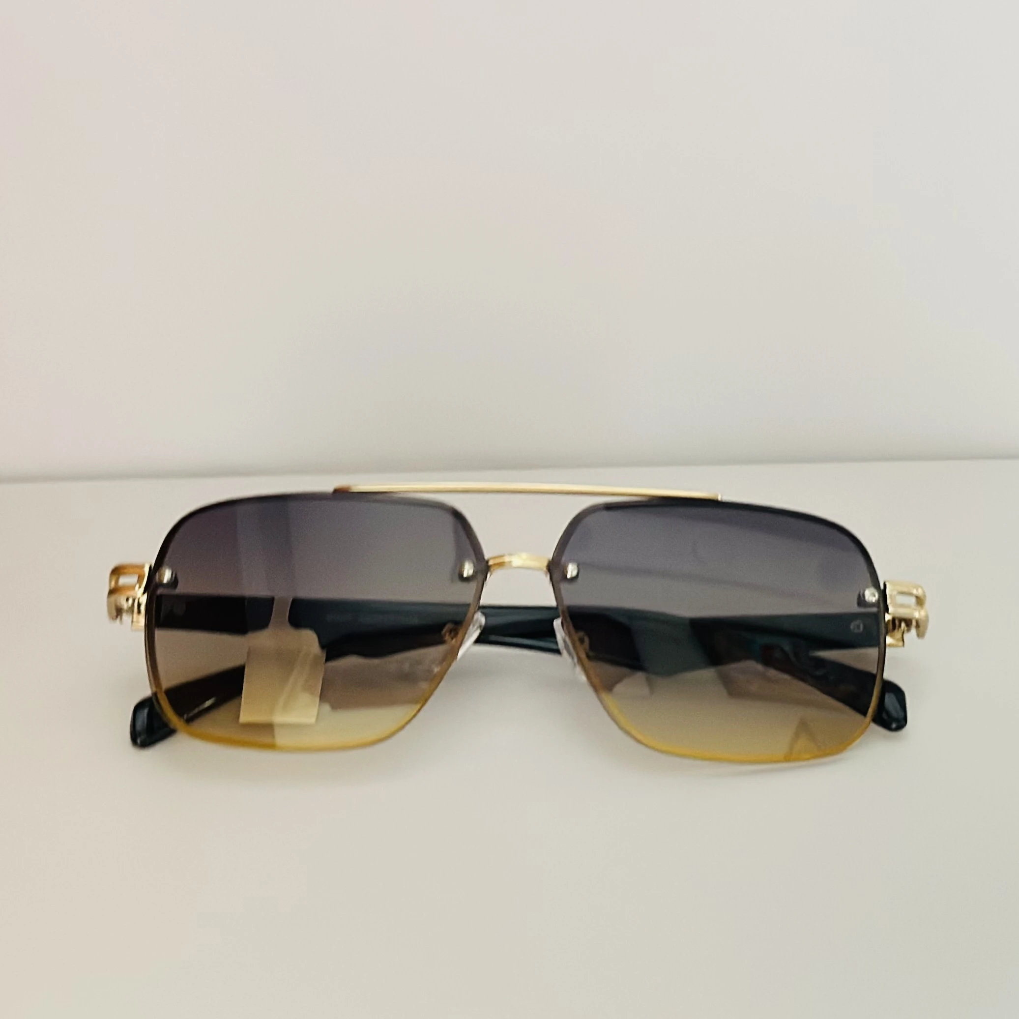square aviator sunglasses with a gold-toned metal frame and brown gradient lenses