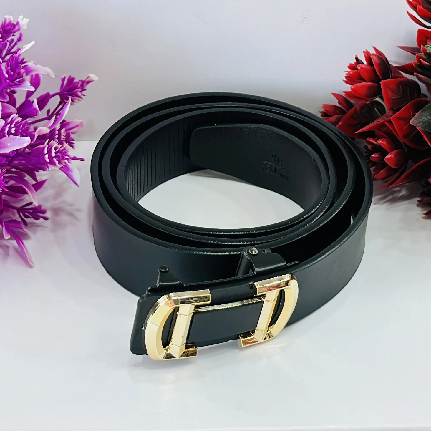 Black leather belt with a gold-tone buckle.