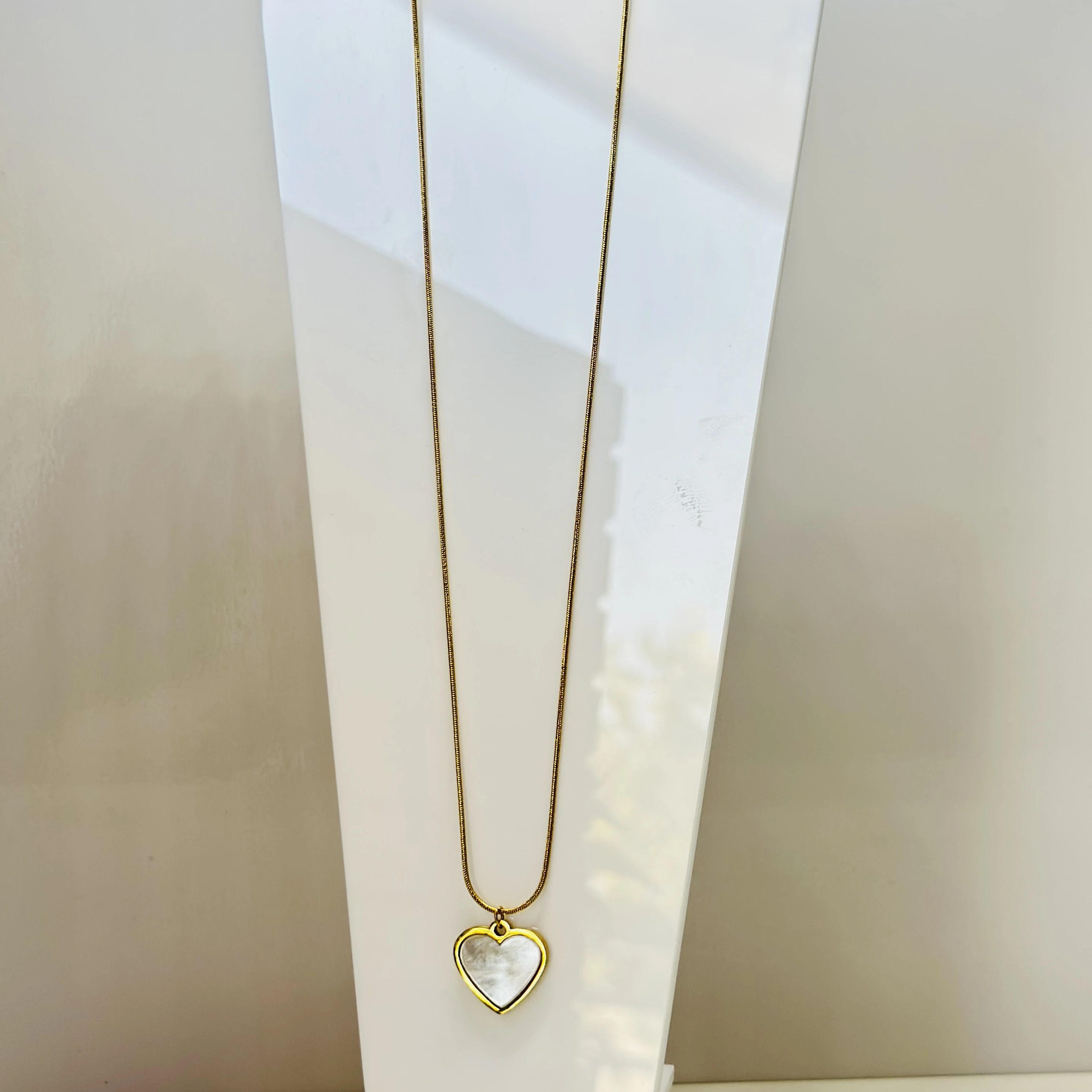 gold-plated snake chain  a white heart pendant.