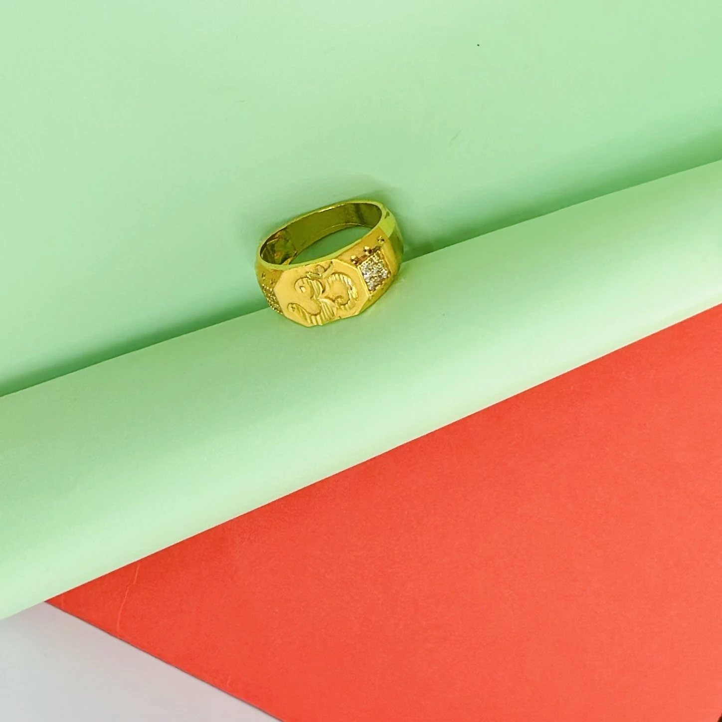 Gold plated men's ring featuring the "Om" symbol and small accent stones.