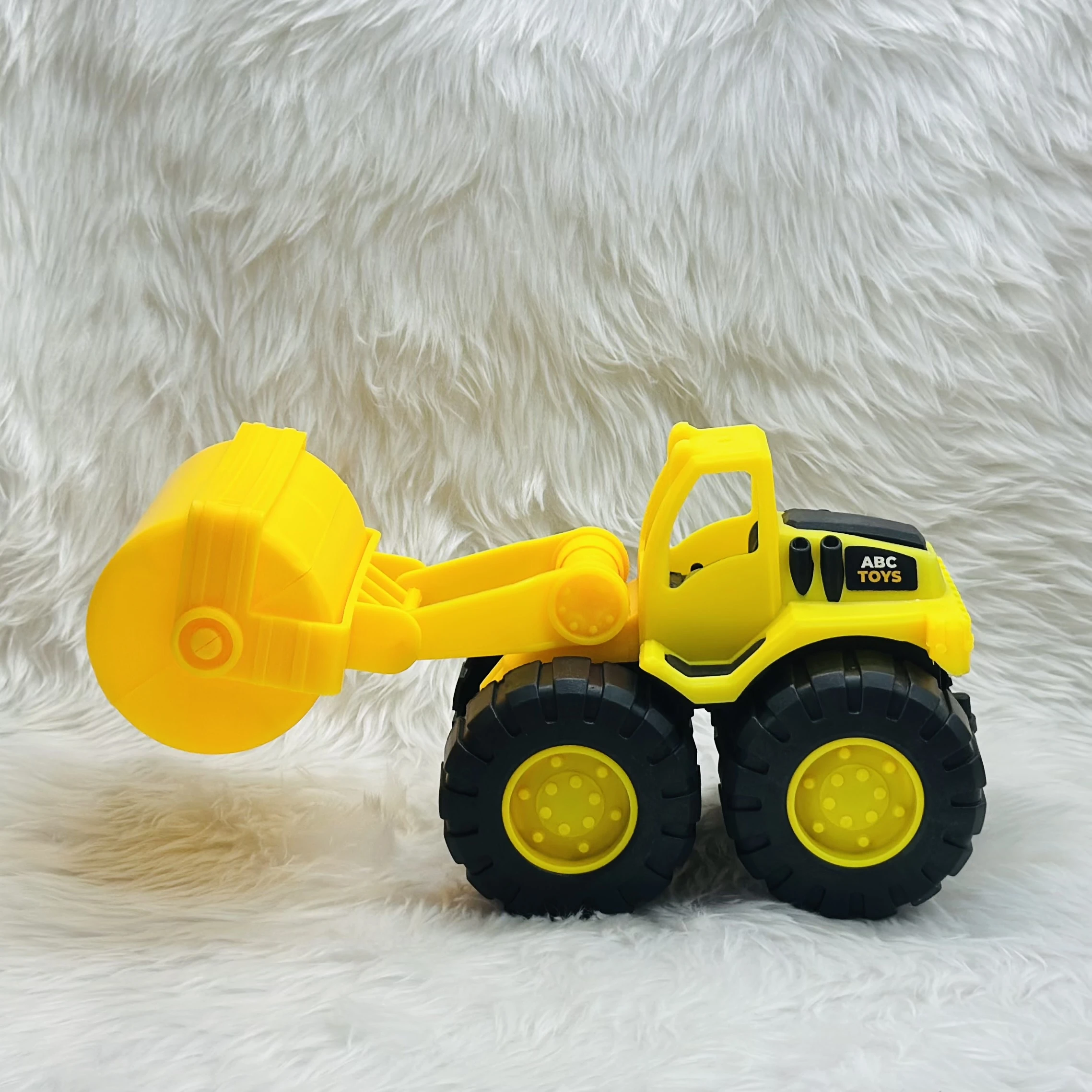 yellow toy construction vehicle, identified as a bulldozer or wheel loader,