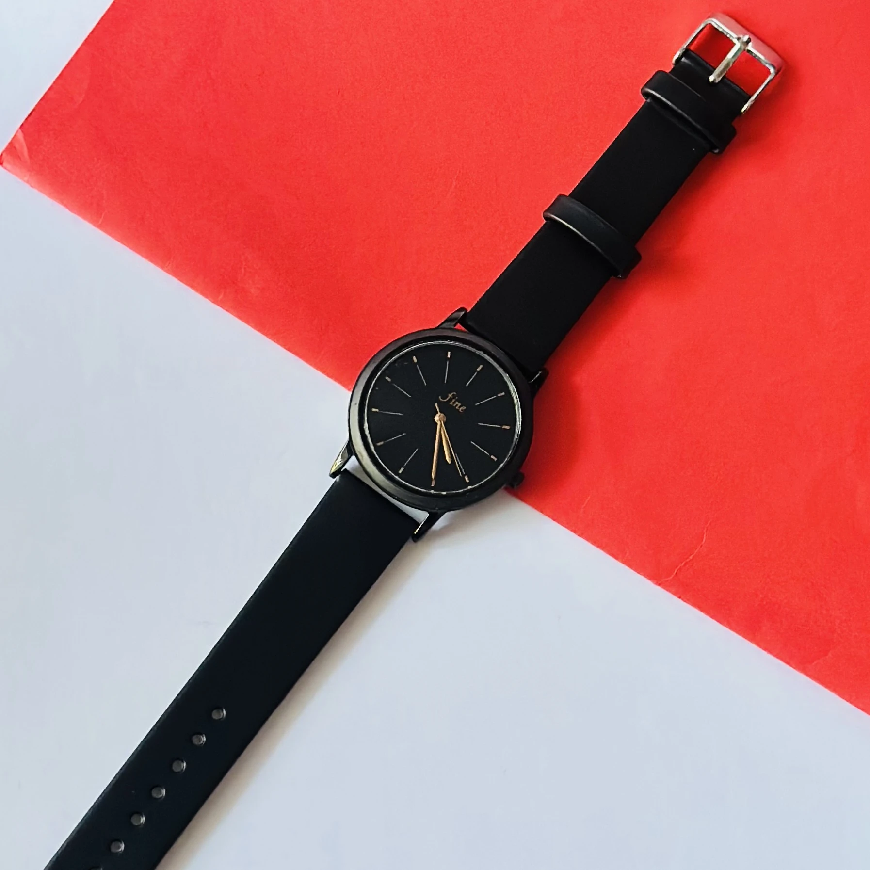 women's analog watch in black with a silicone strap.