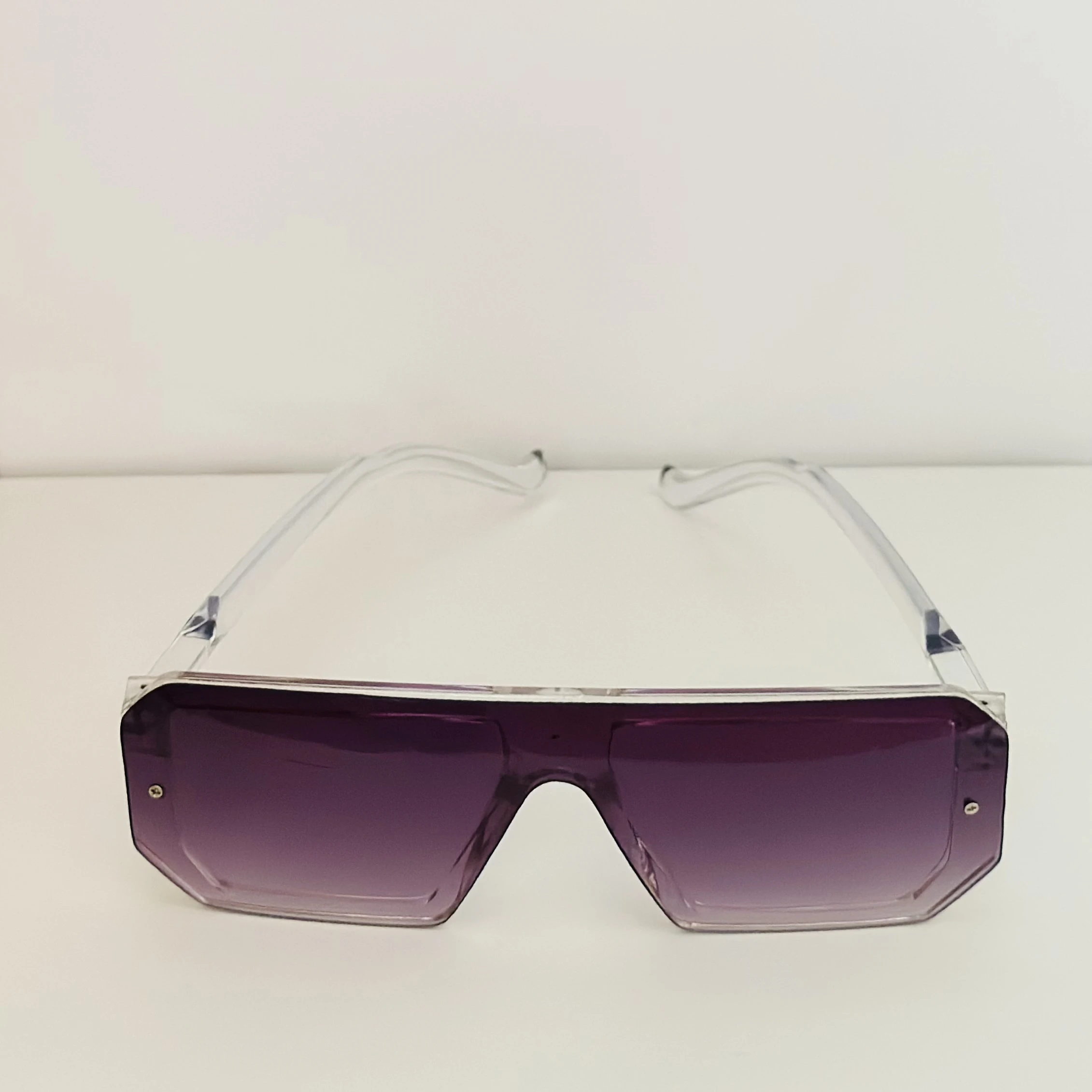 Oversized shield sunglasses with a rimless, flat-top design and purple gradient lenses.