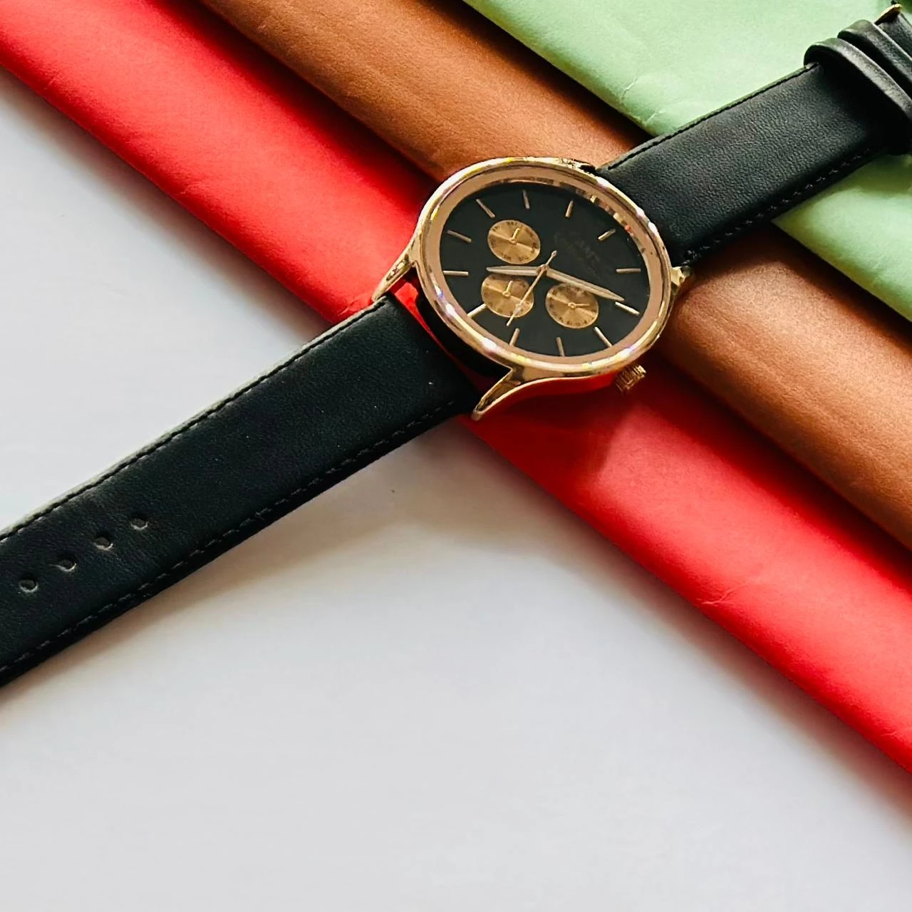 Round analog watch with a black leather strap