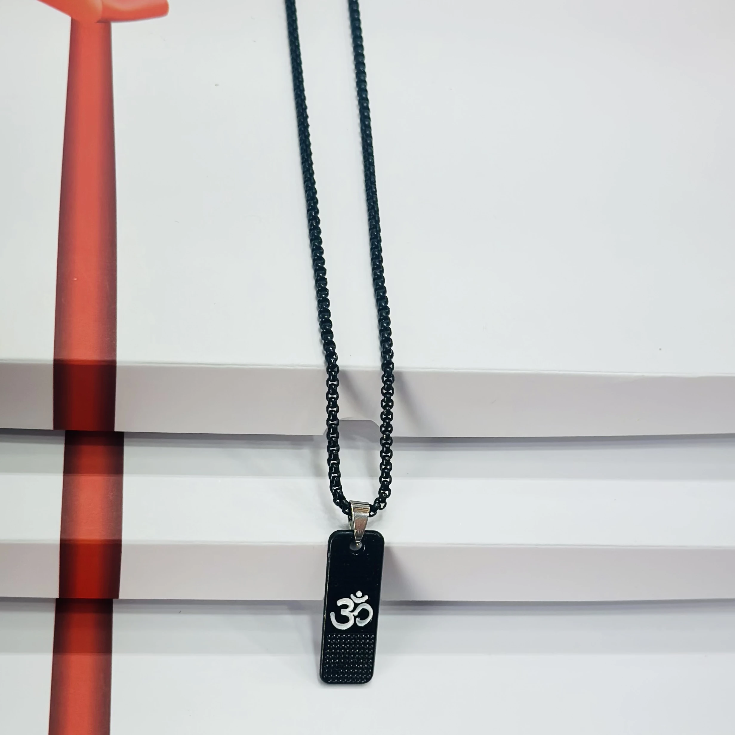 Black stainless steel pendant necklace with the white Om symbol.