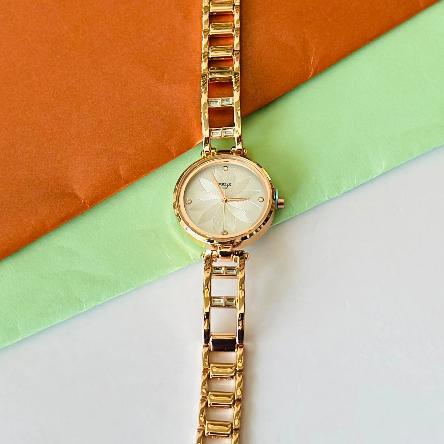 analog watch with a white dial and a rose gold metal strap