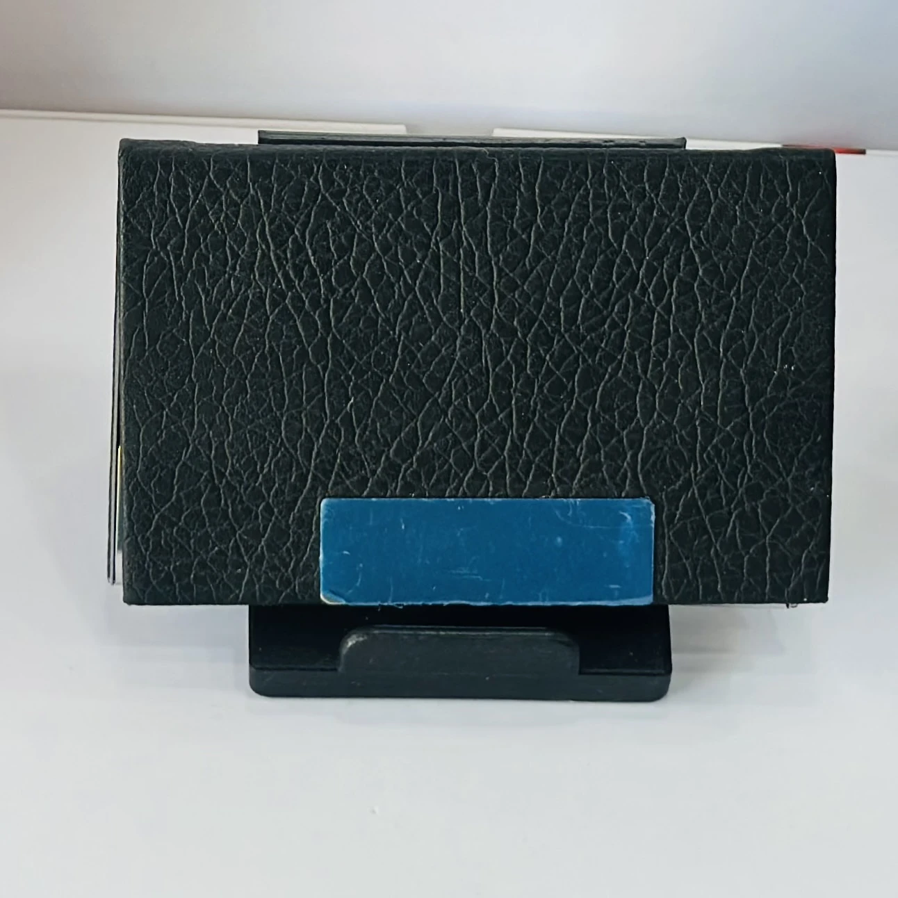 Black faux leather and metal business card holder.