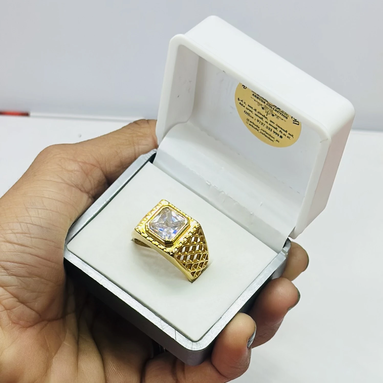 Gold plated men's ring with a square-cut cubic zirconia stone.