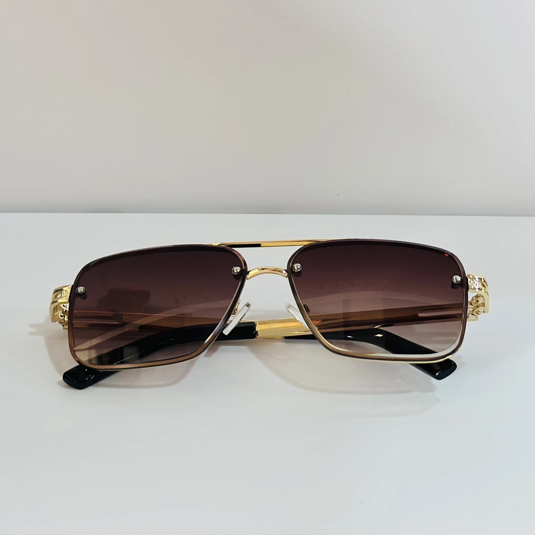 pair of Maybach-style sunglasses with gold-toned frames and brown gradient lenses.