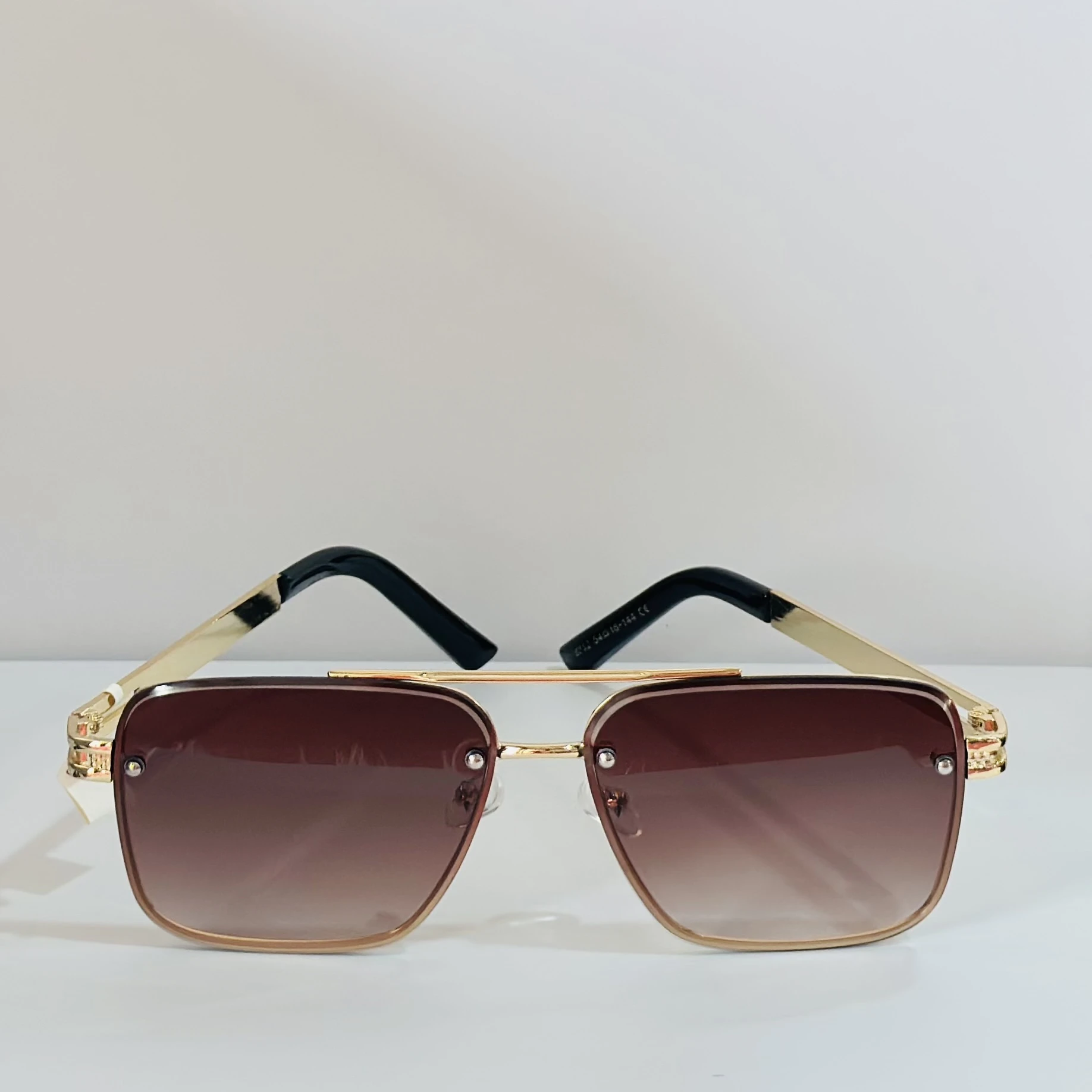 pair of Maybach-style sunglasses with gold-toned frames and brown gradient lenses.