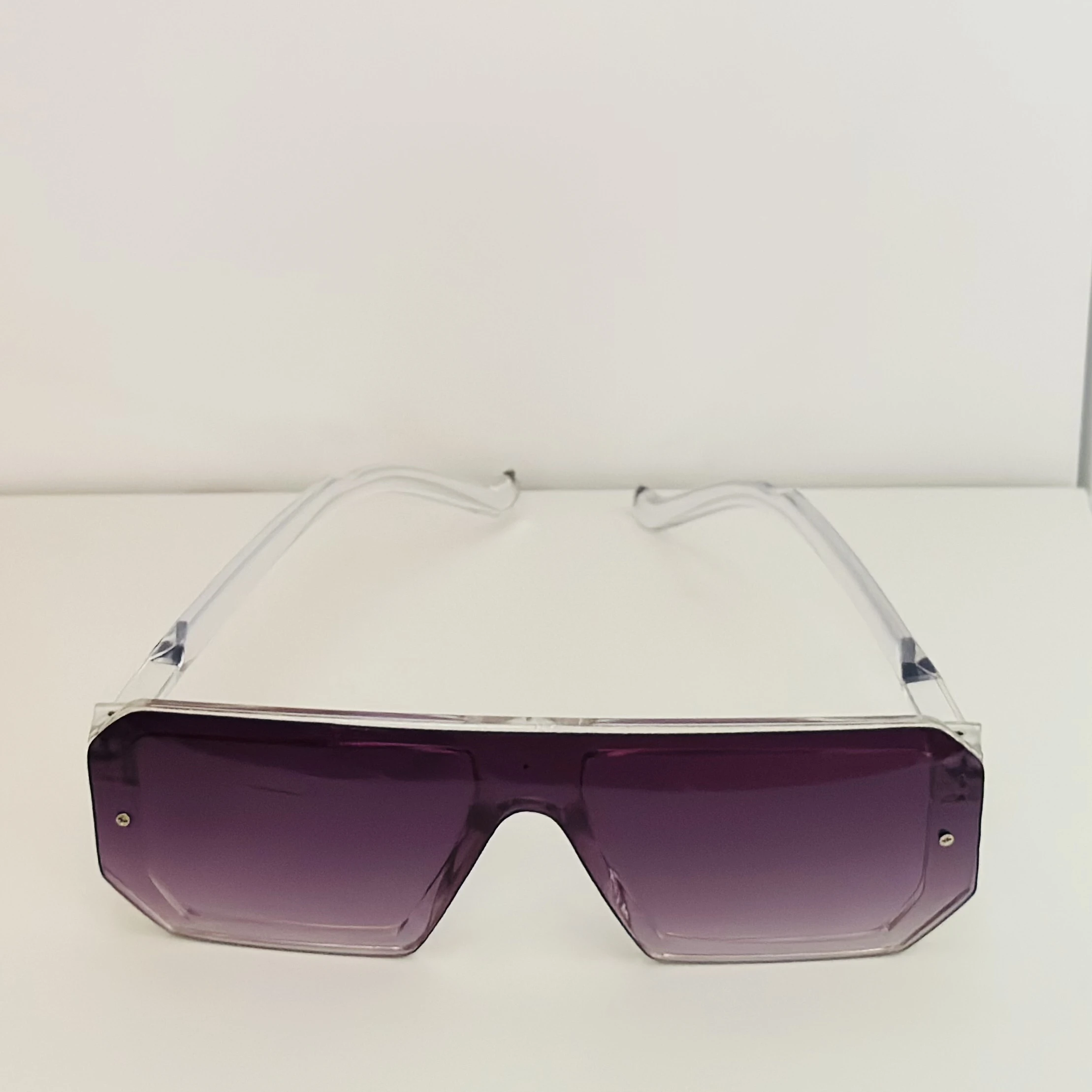 Oversized shield sunglasses with a rimless, flat-top design and purple gradient lenses.