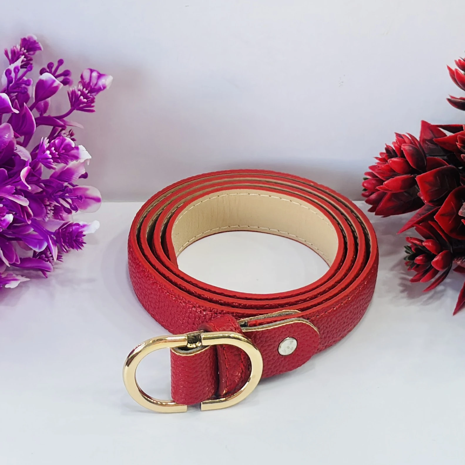 Red  leather belt with a gold-colored buckle.