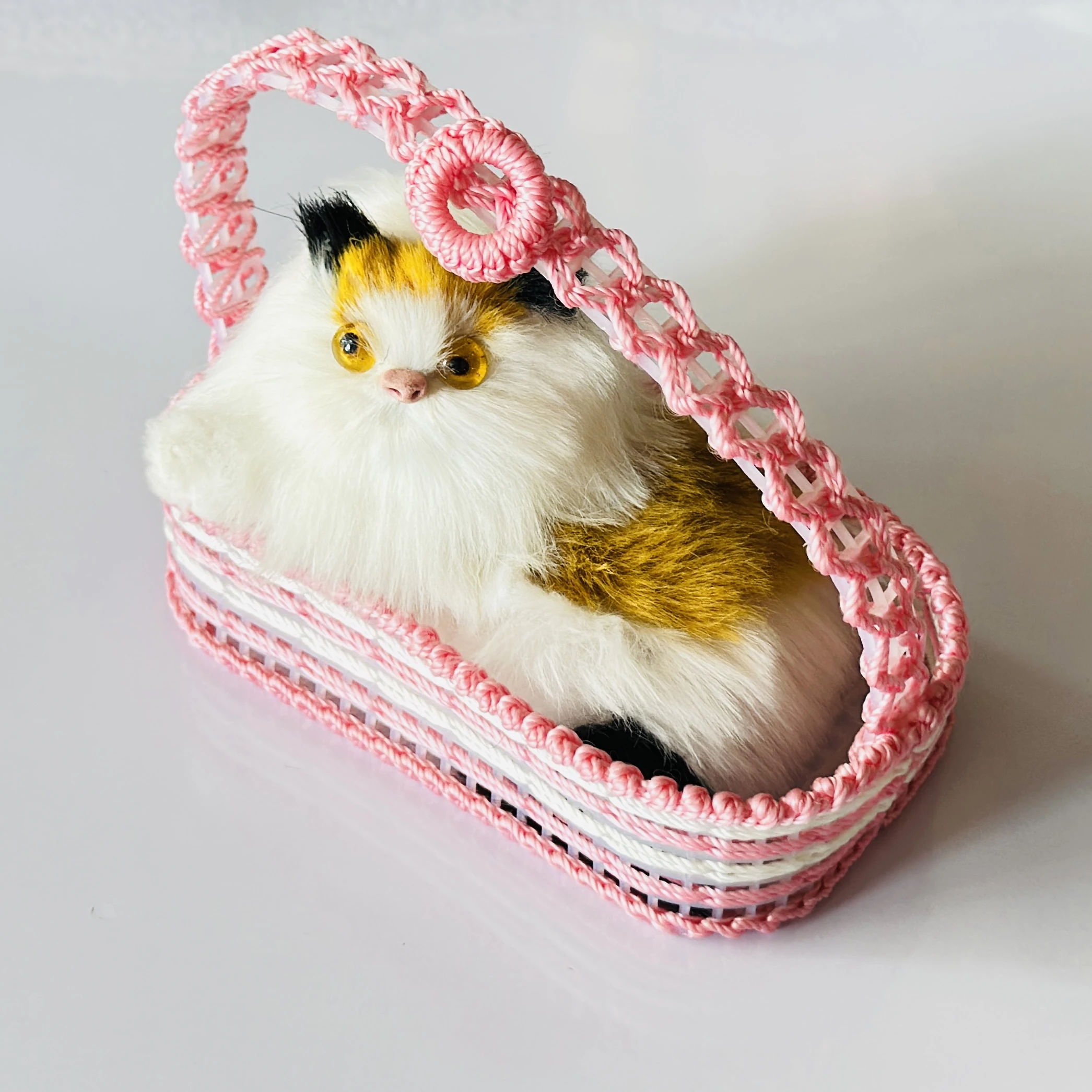 Decorative showpiece featuring a plush cat sitting inside a pink woven basket