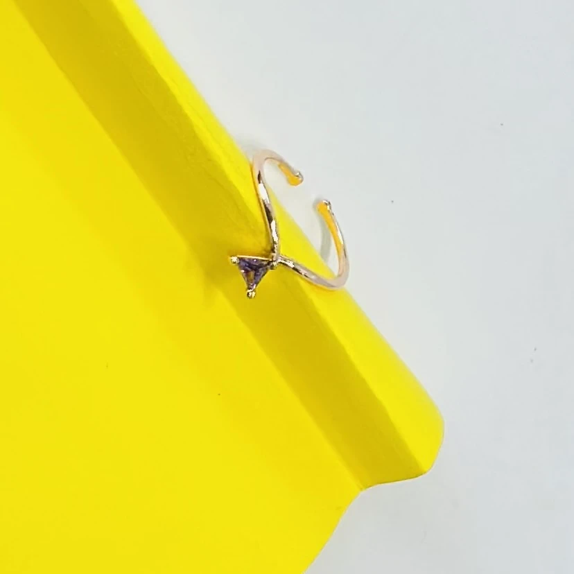 An adjustable bypass ring with a trillion cut amethyst stone.