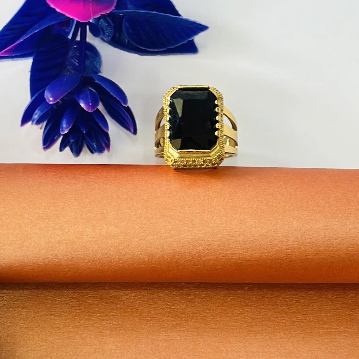 Gold plated ring with a black stone and artificial diamonds.