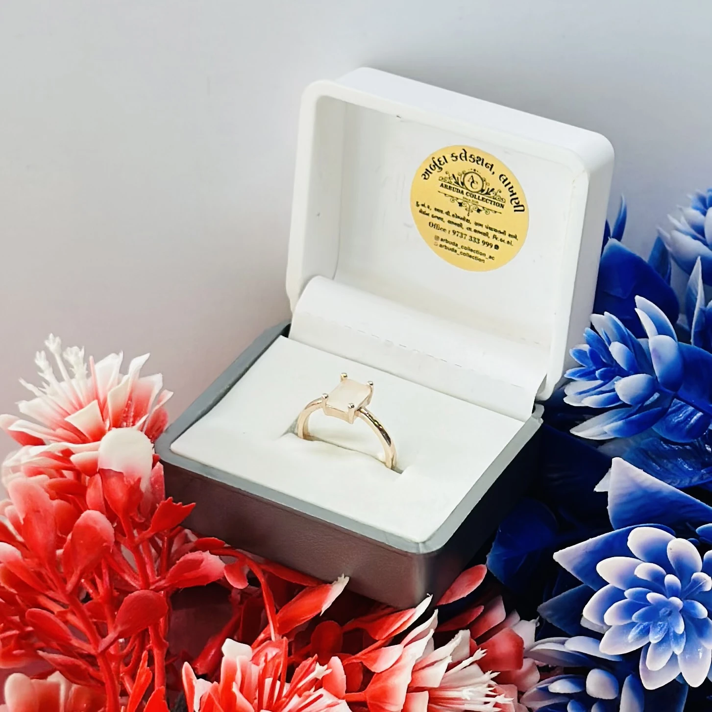 Rose gold-toned ring with a square-cut white stone.