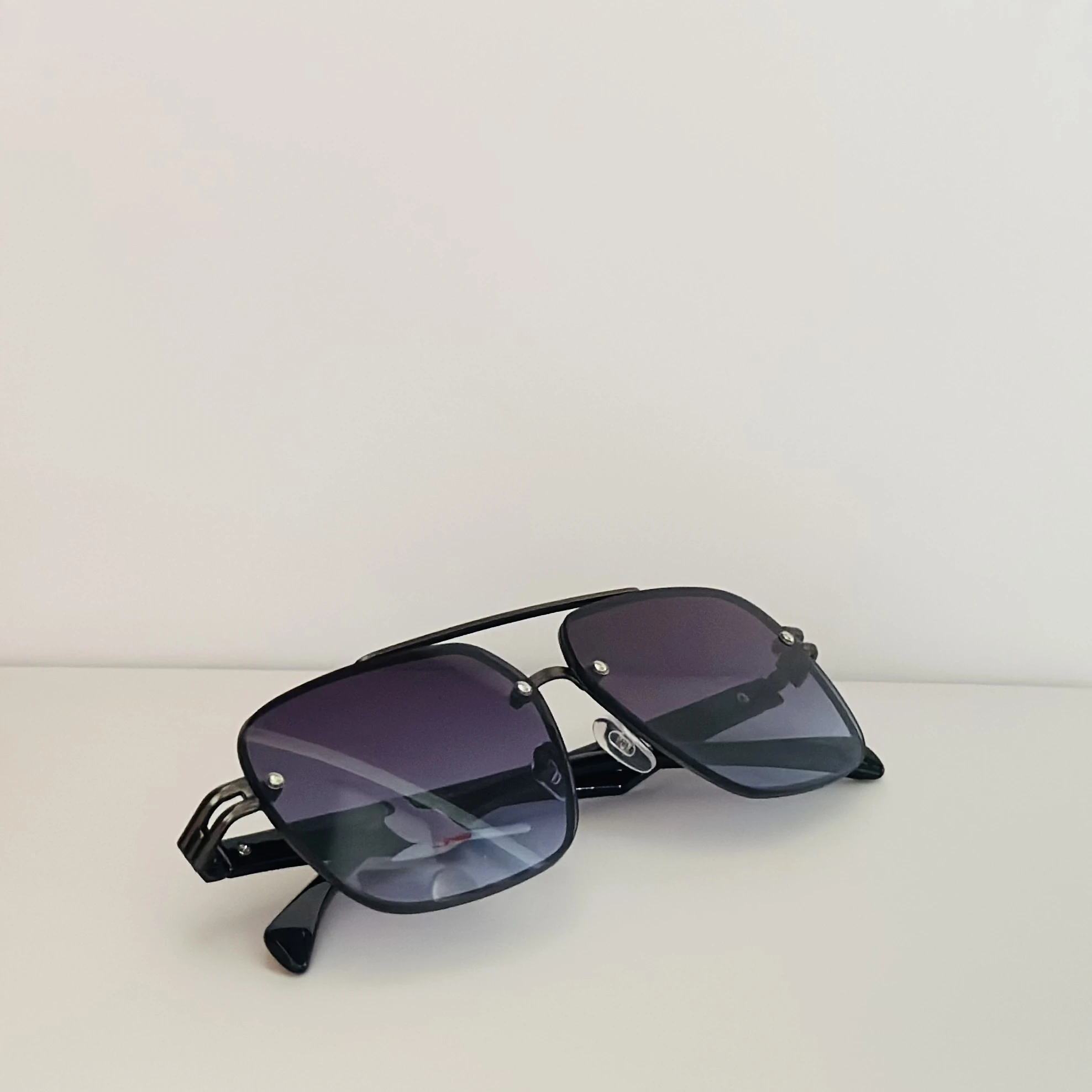 black rimless aviator sunglasses with blue gradient lenses.