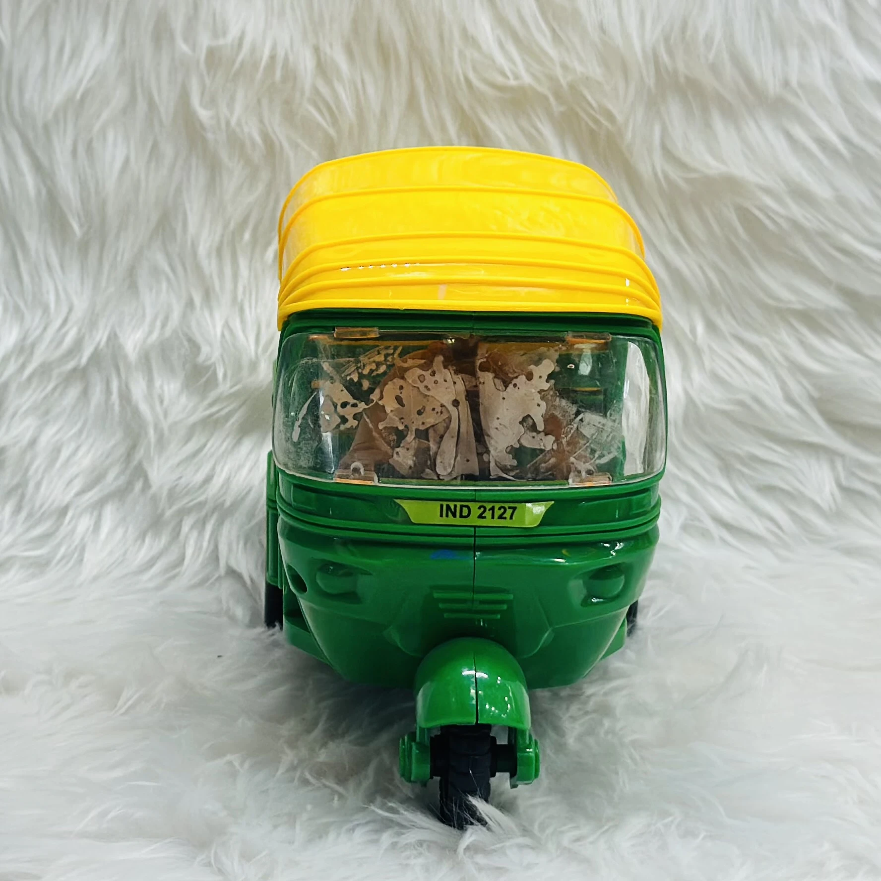Yellow plastic toy auto rickshaw.