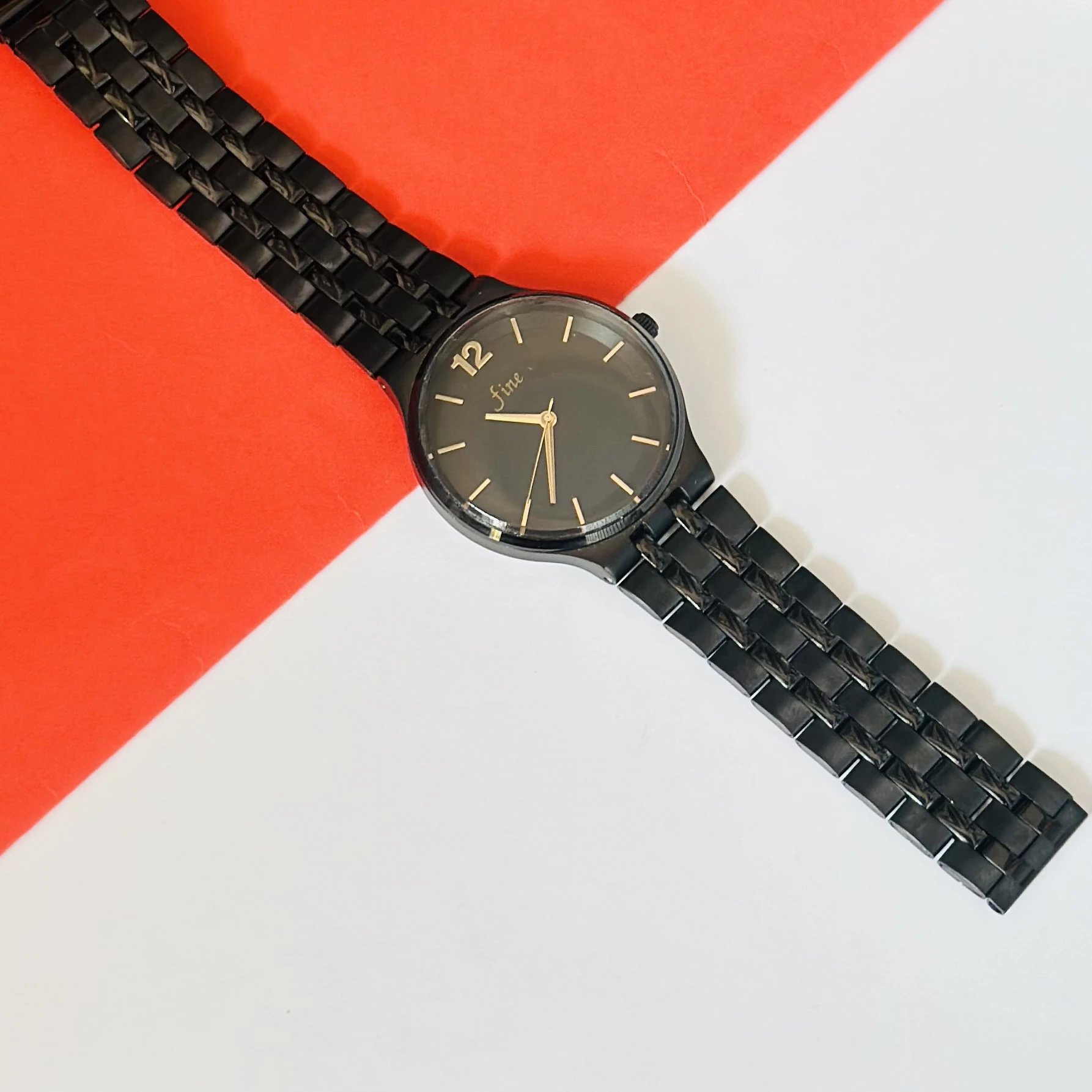 Analog watch with a black stainless steel bracelet and black dial.