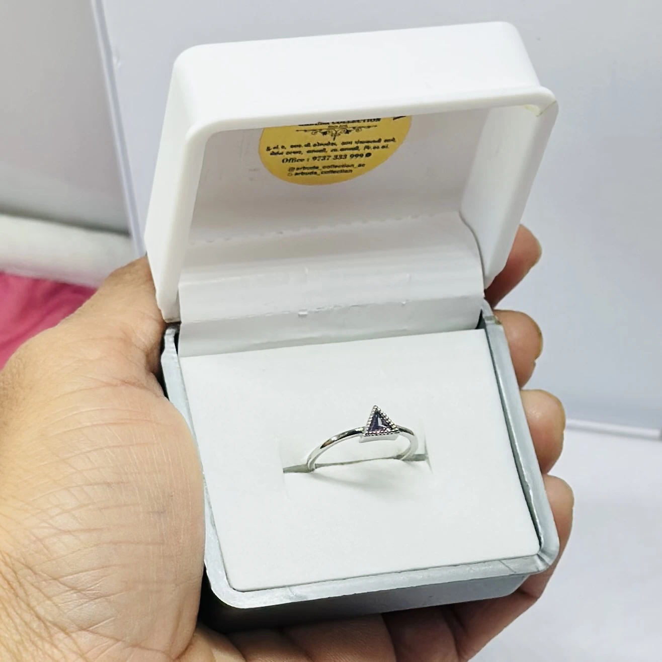 Gold solitaire engagement ring with a single round clear gemstone.