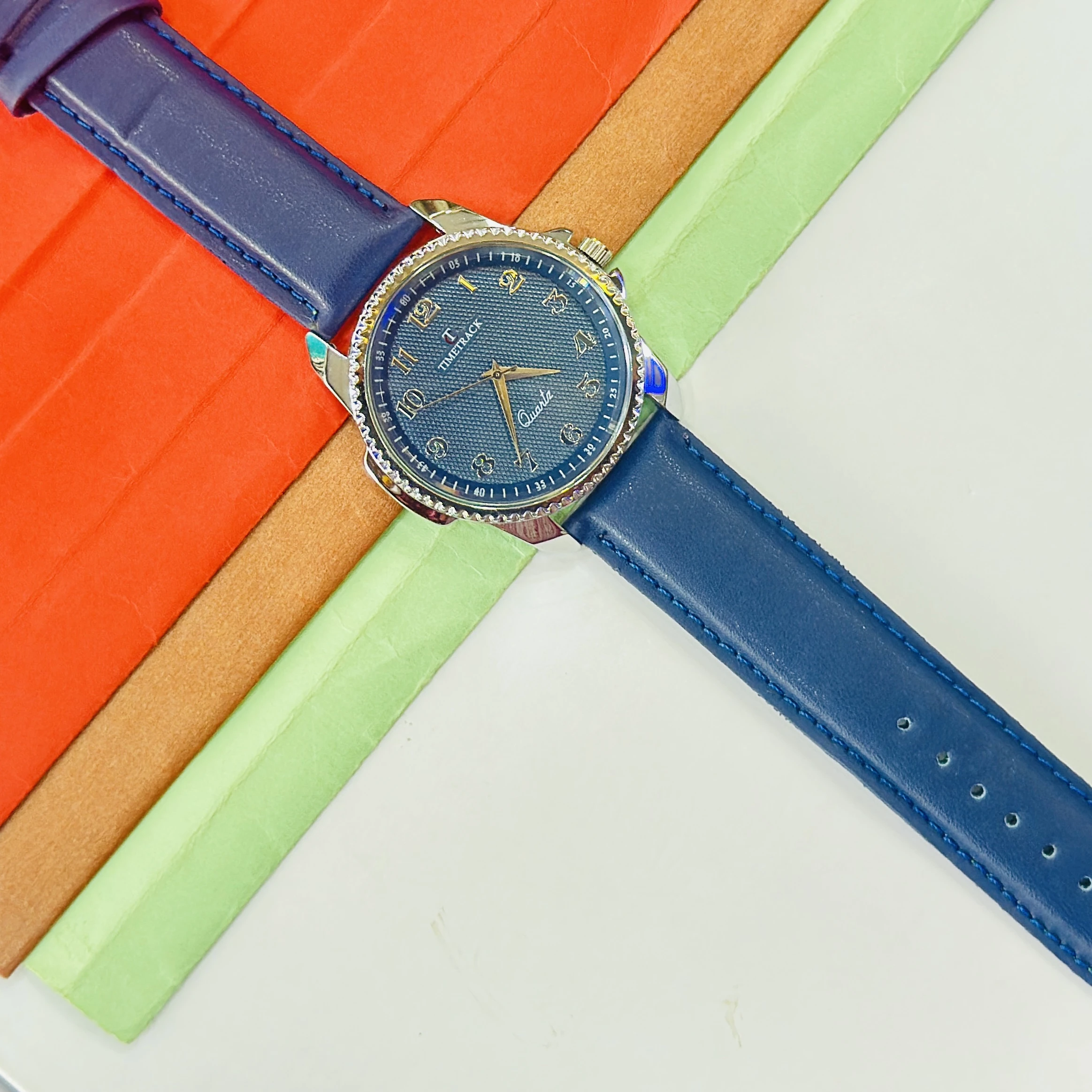quartz analog watch features a blue dial and a matching navy blue leather strap