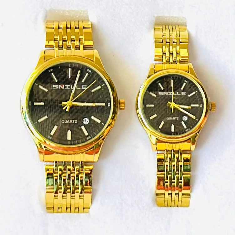 pair of Snille Date Series analog quartz watches for men and women with gold-tone link bracelets and black dials.