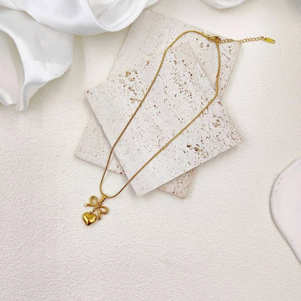 Lumora Forever Gleaming necklace features a heart and bow pendant
