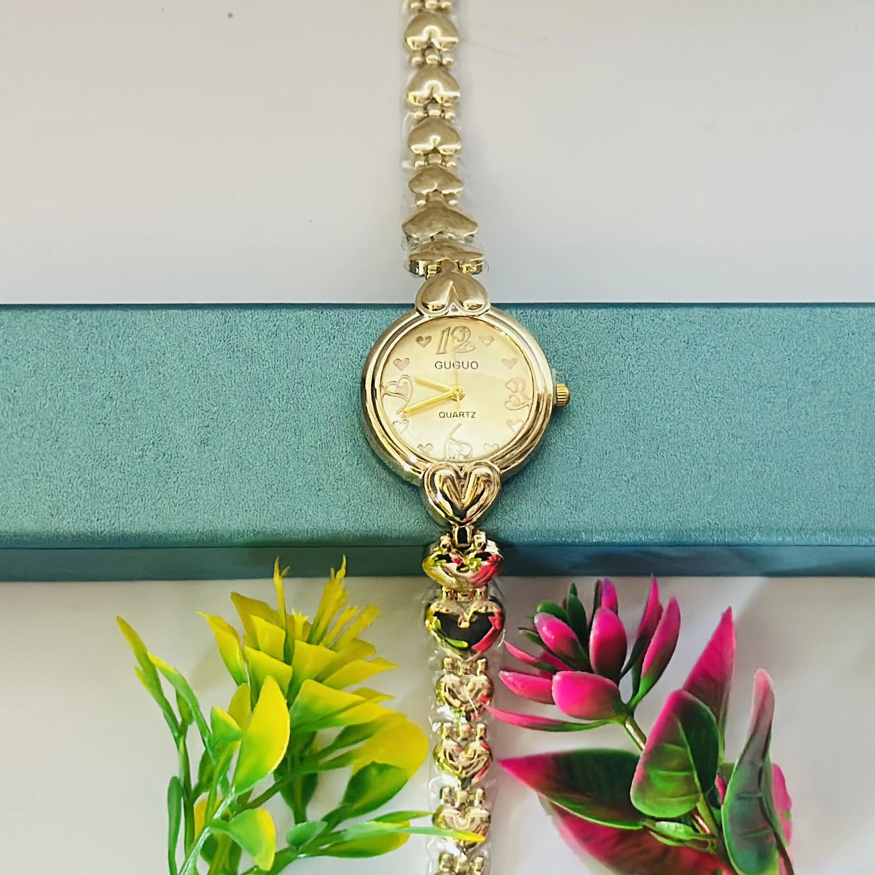 gold-toned GUGUO quartz analog watch with a heart-shaped link bracelet.