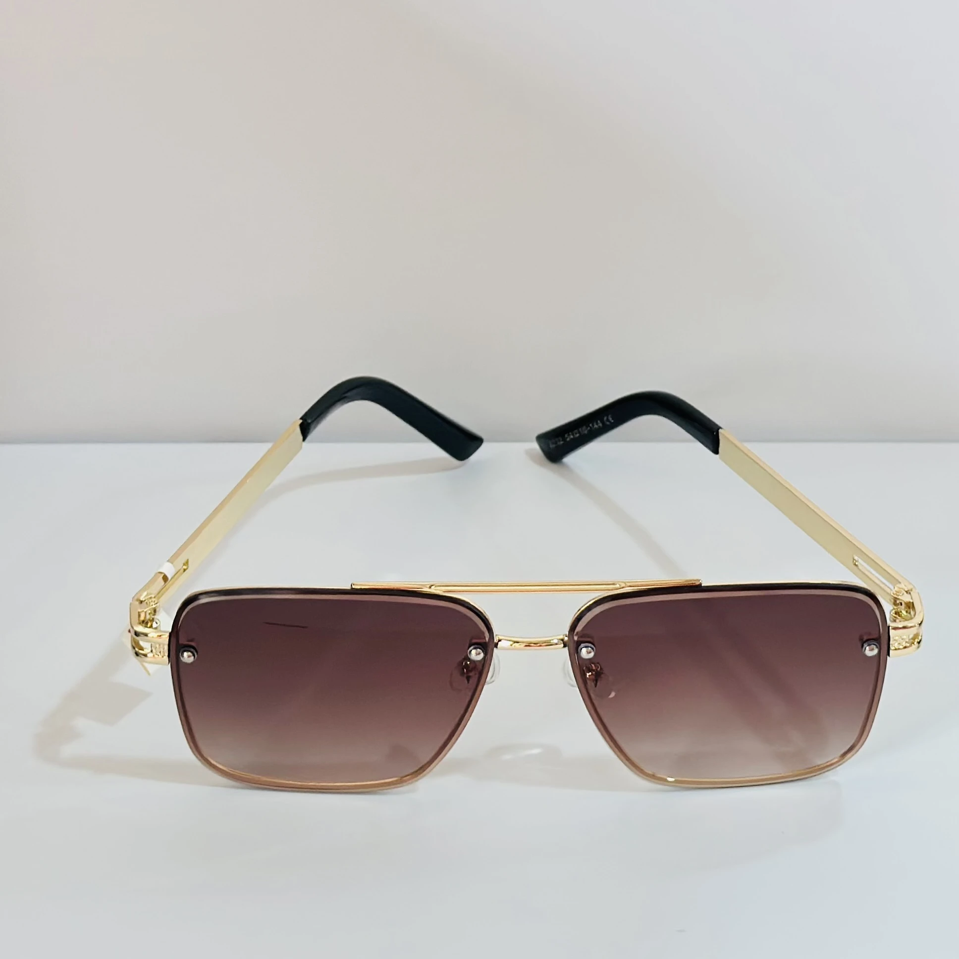 pair of Maybach-style sunglasses with gold-toned frames and brown gradient lenses.