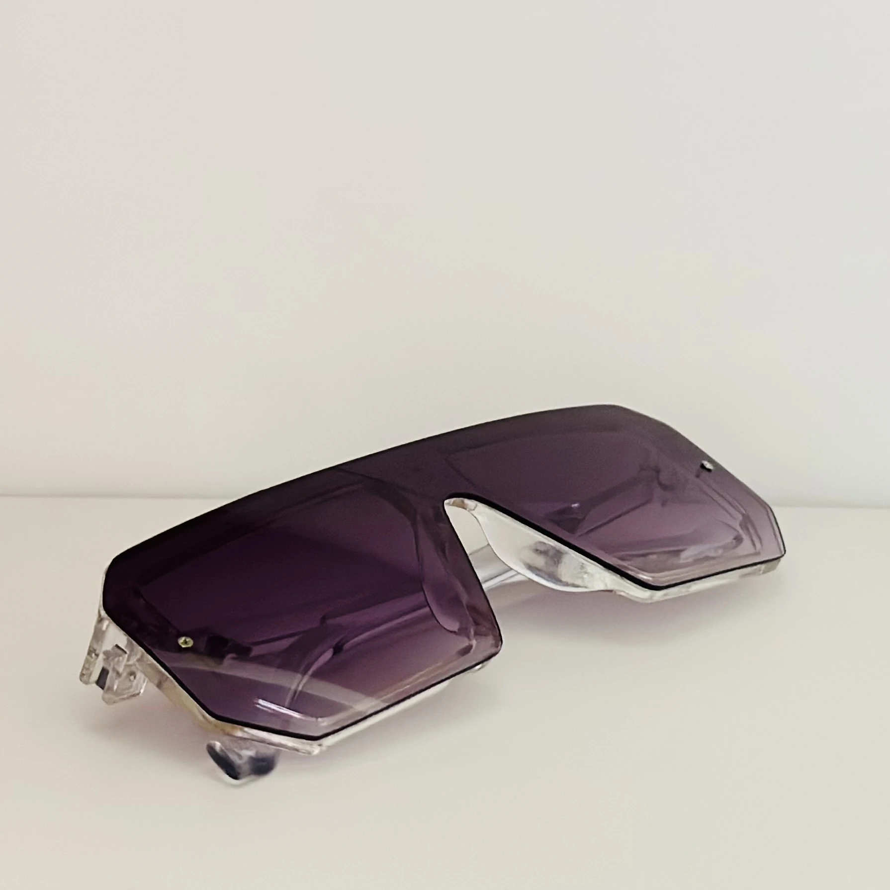 Oversized shield sunglasses with a rimless, flat-top design and purple gradient lenses.