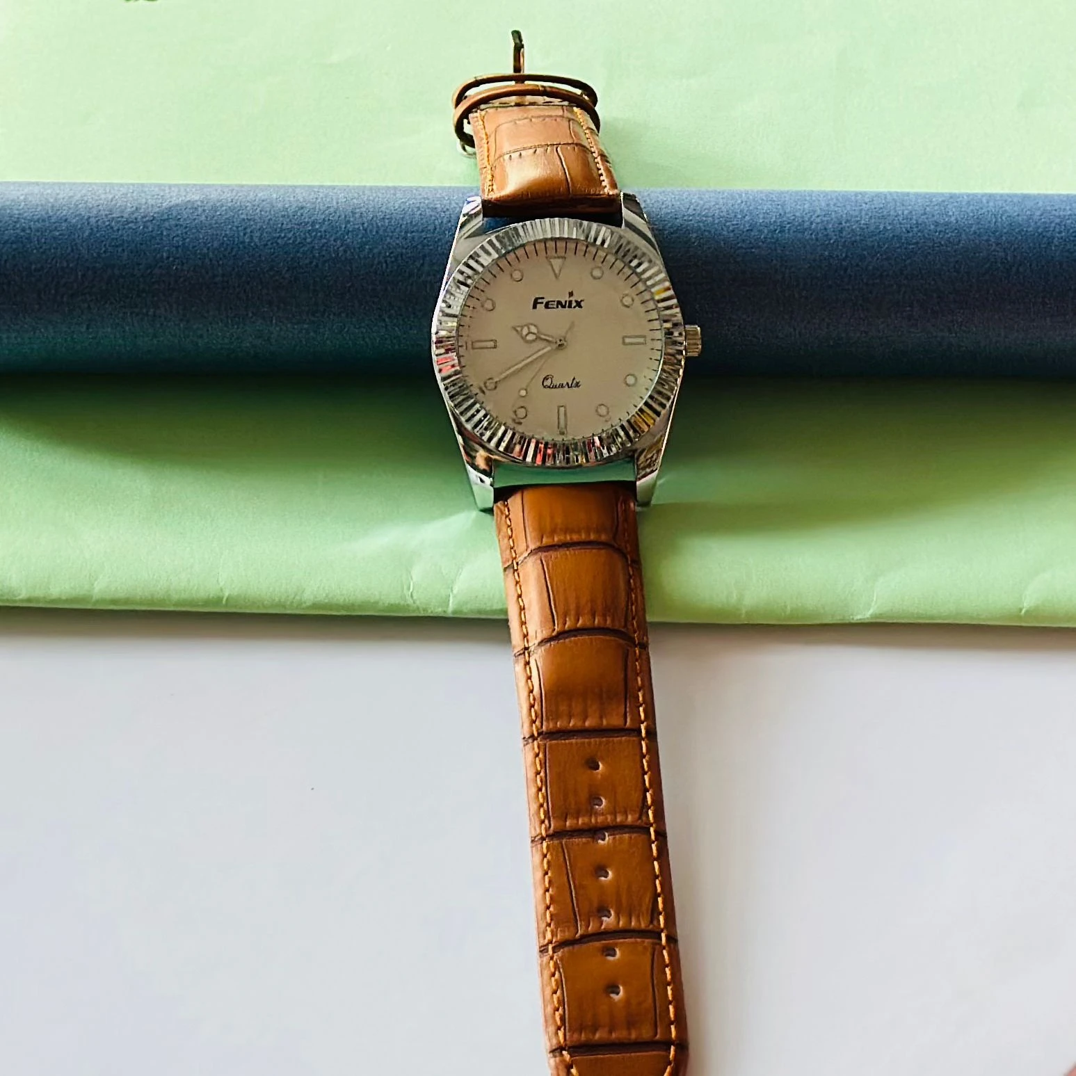 Round analog watch with a brown leather strap