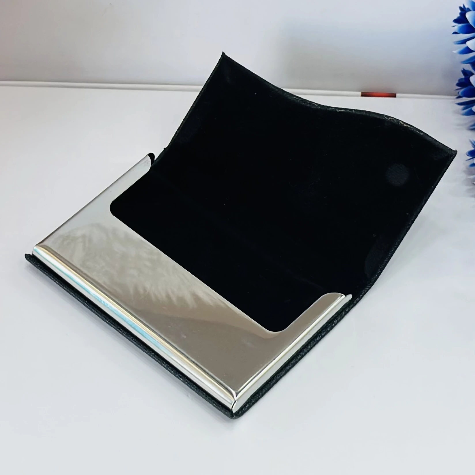 black faux leather and metal business card holder.
