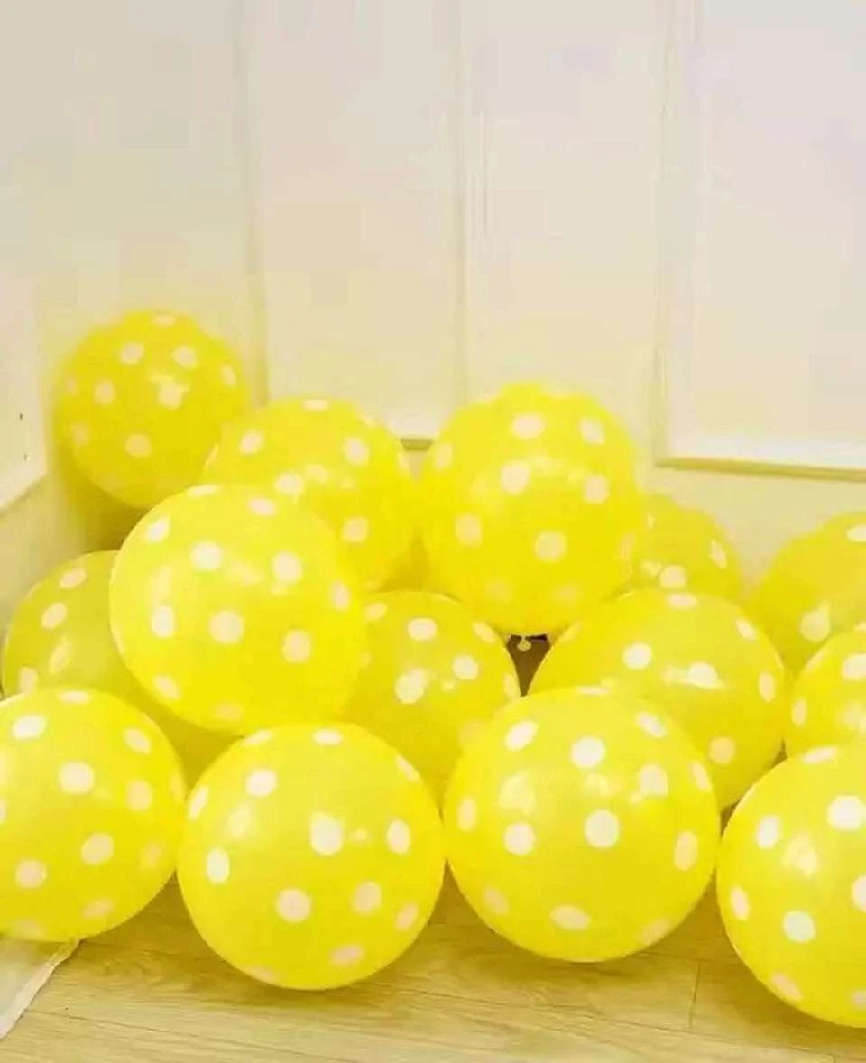 package of Yellow party balloons with white polka dots.