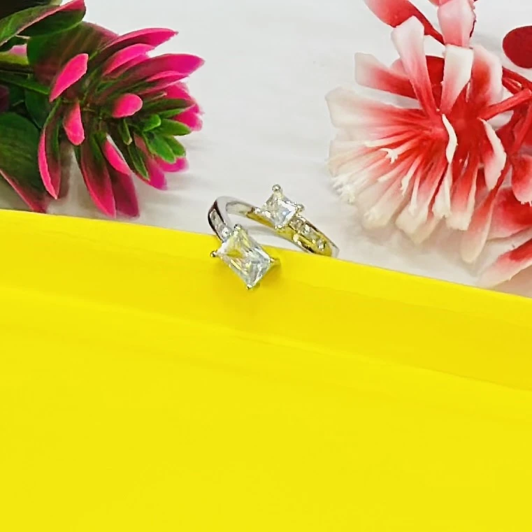 silver-toned ring featuring two prominent princess-cut stones