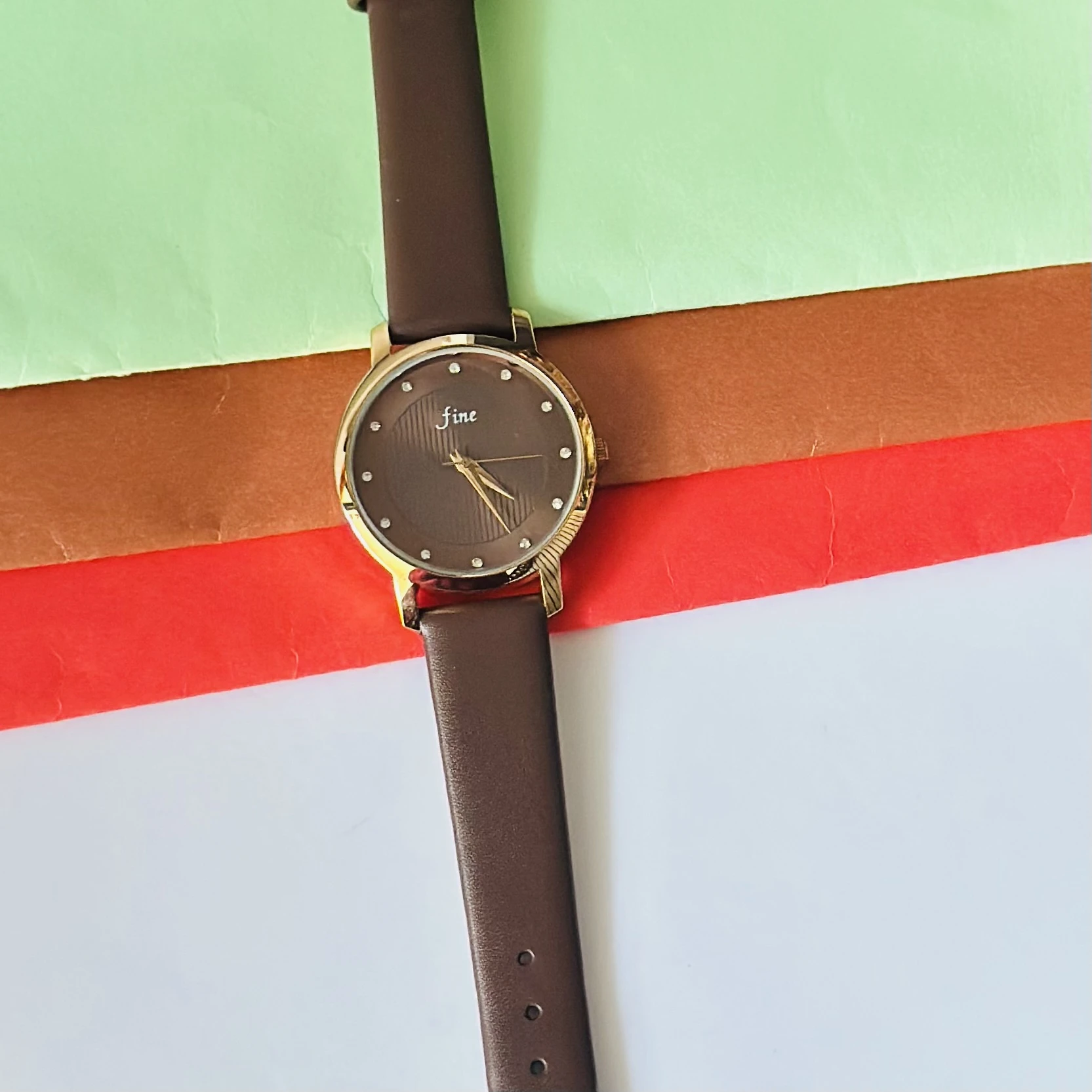 Analogue women's wrist watch with a brown strap.