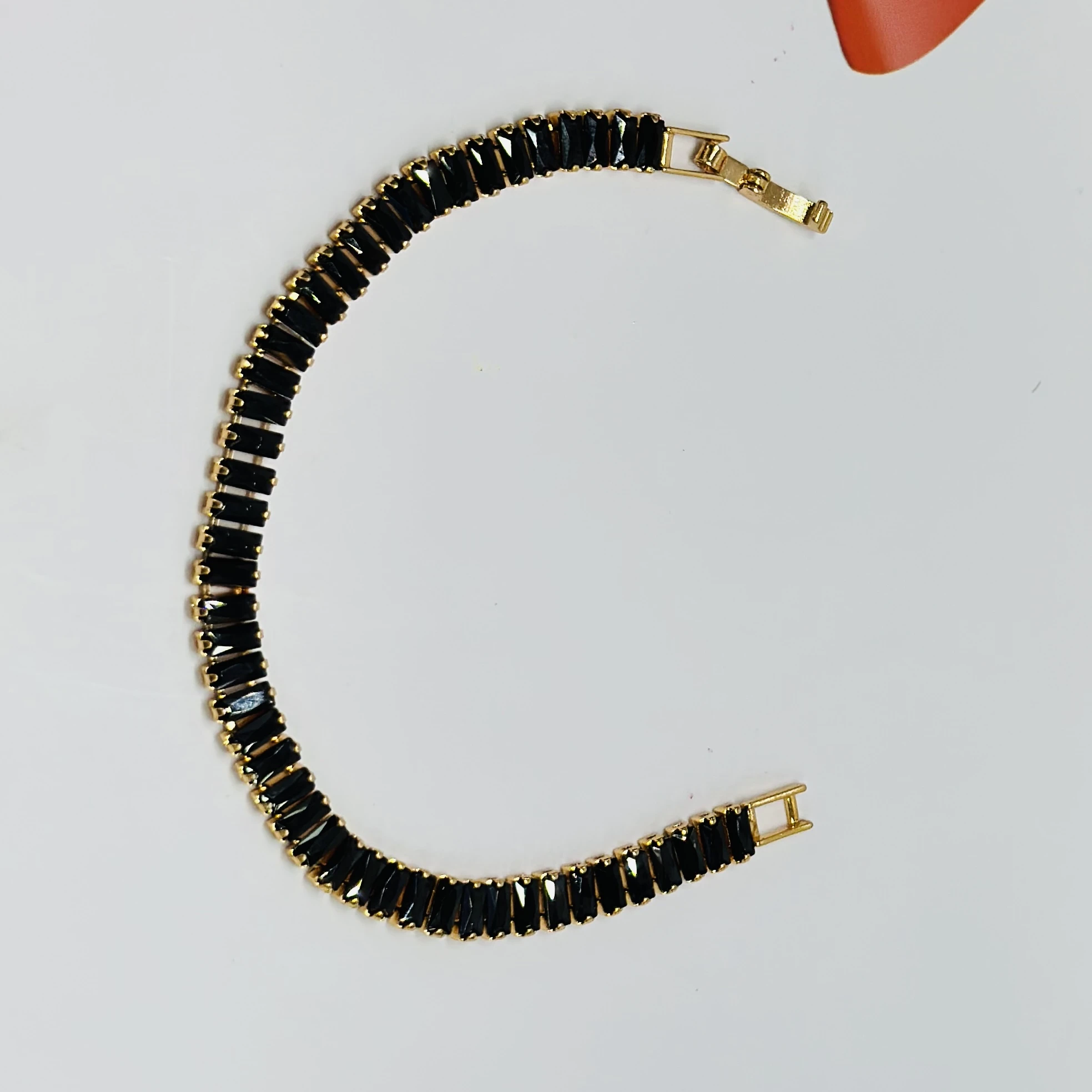 Gold plated black baguette tennis bracelet with artificial stones.