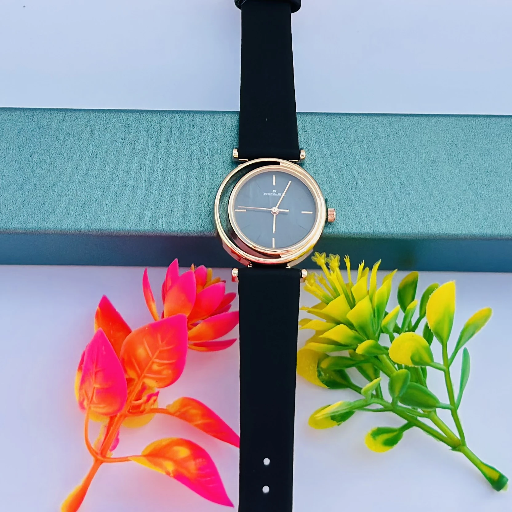 Analog with Pink Dial watch for women with a black plastic strap.