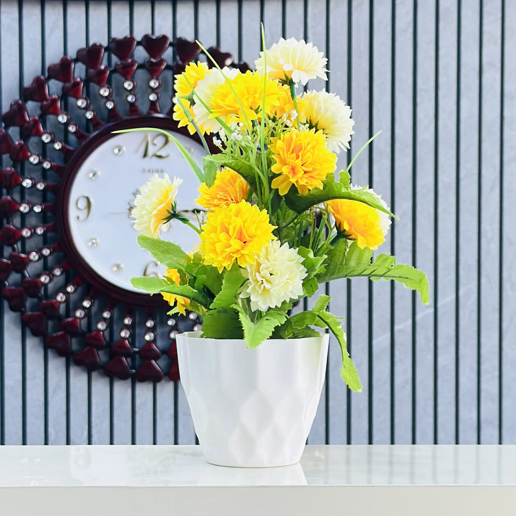 an artificial flower arrangement in a white pot.