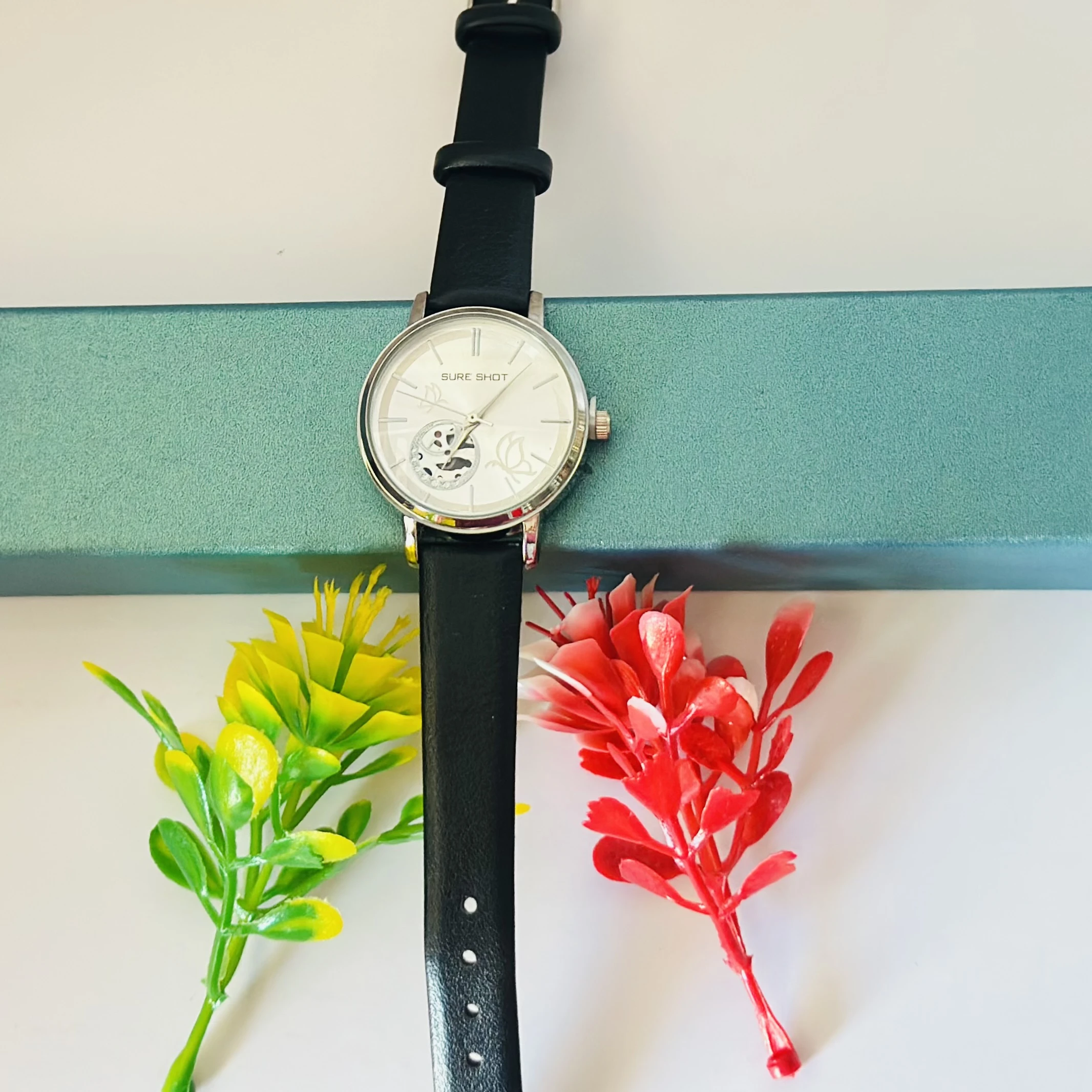 Sure Shot analog watch with a black leather band and silver-tone case.