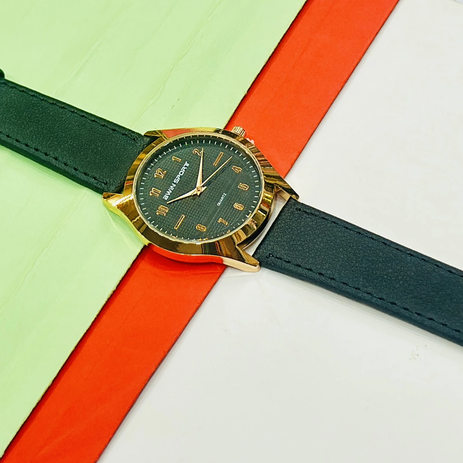 Quartz watch with a brown leather strap and a black dial.