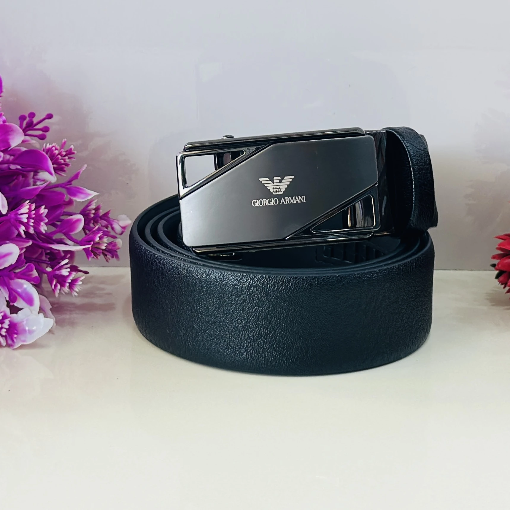 Giorgio Armani black leather ratchet belt with a metal logo buckle.