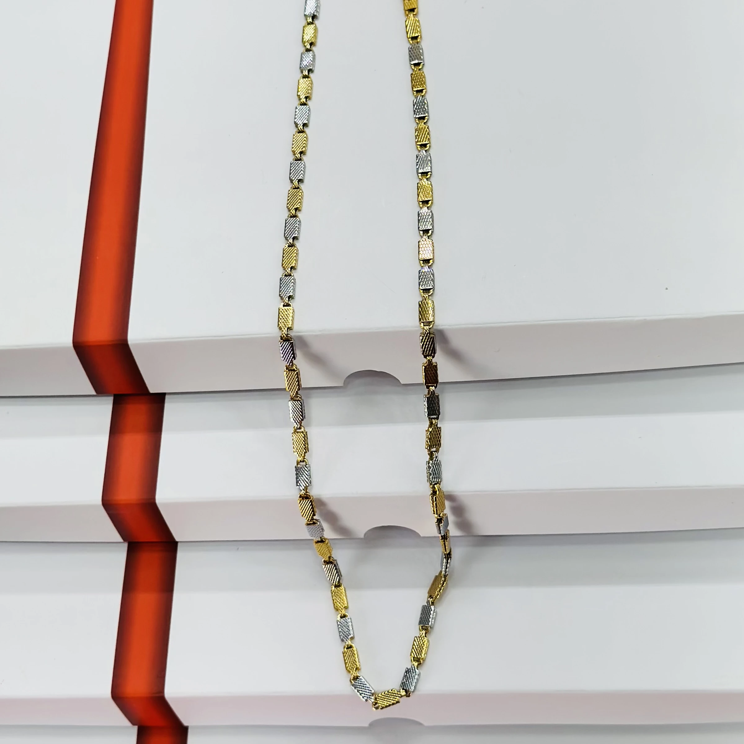Two tone silver and golden-colored stainless steel chain
