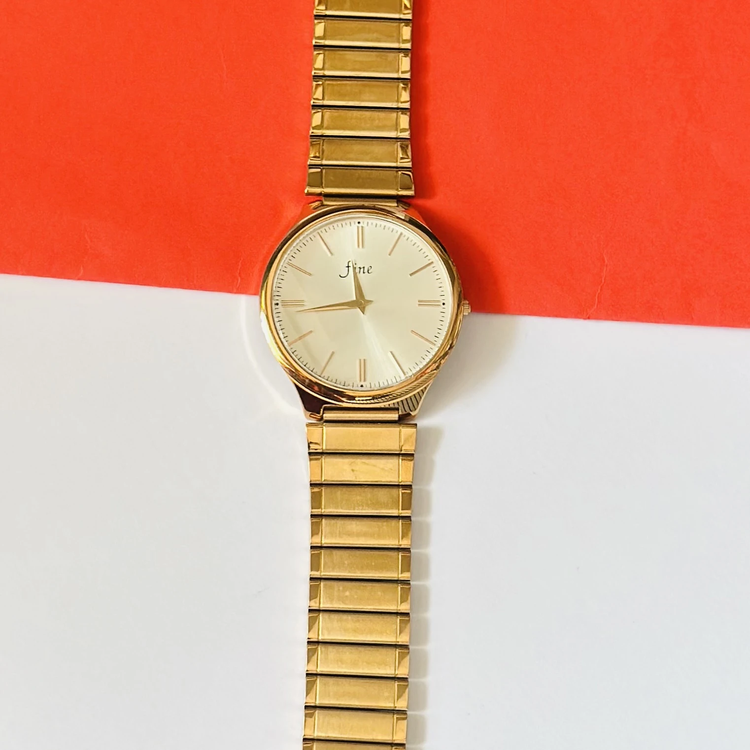 Gold toned analog watch with a stainless steel strap