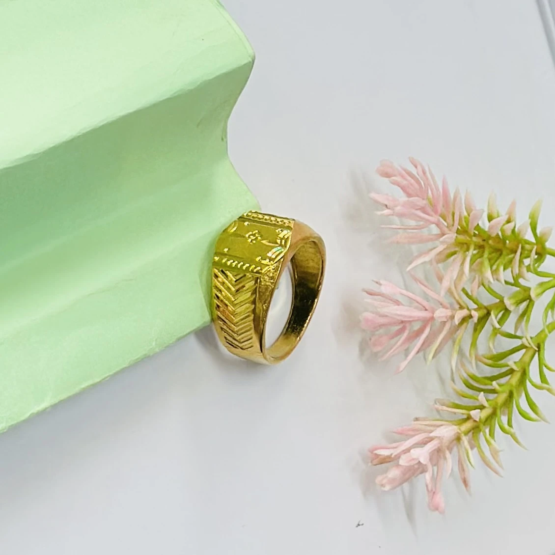 Gold toned signet ring with engraved detailing.