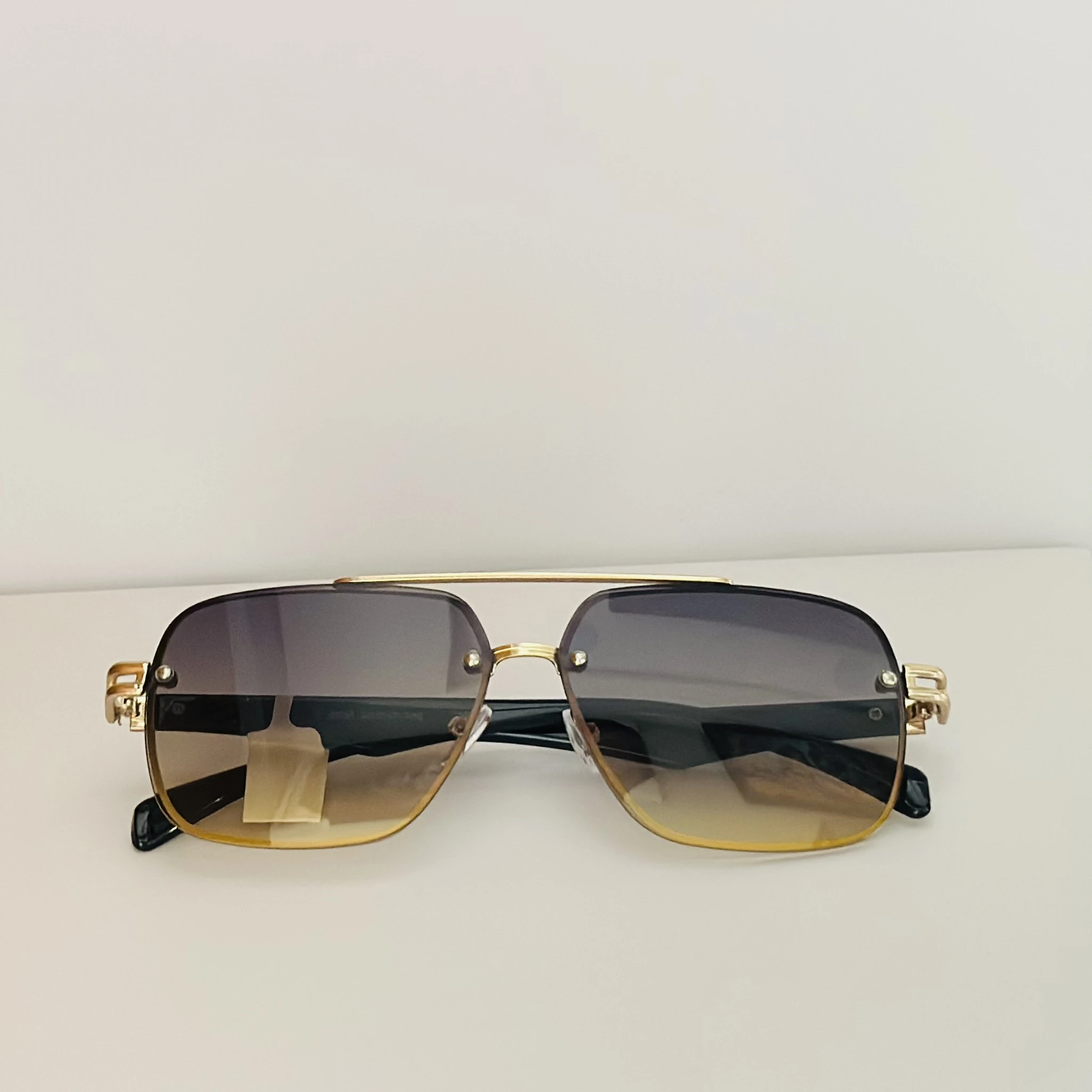 square aviator sunglasses with a gold-toned metal frame and brown gradient lenses