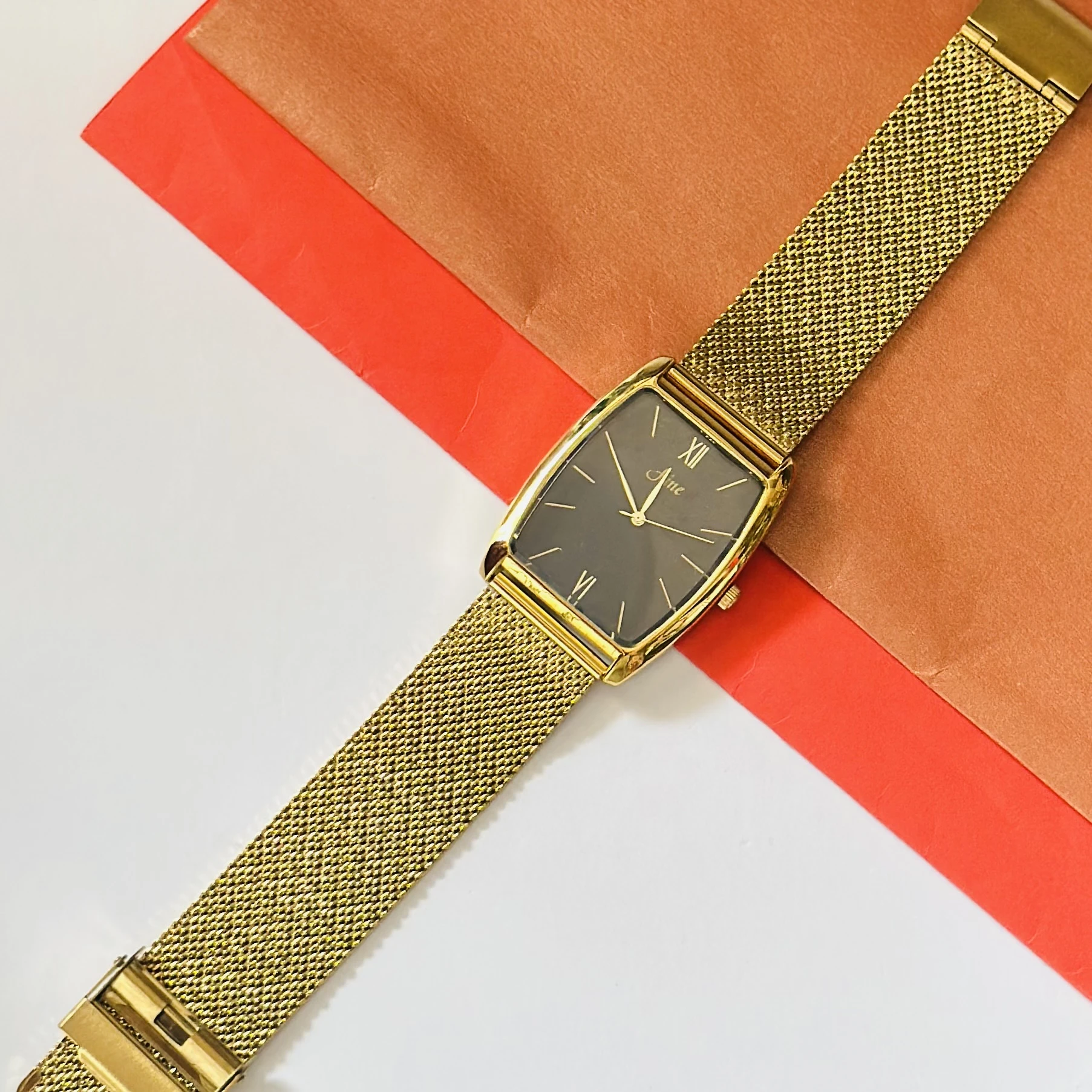 Aine vintage-style gold-tone rectangular quartz mesh watch with a black dial.
